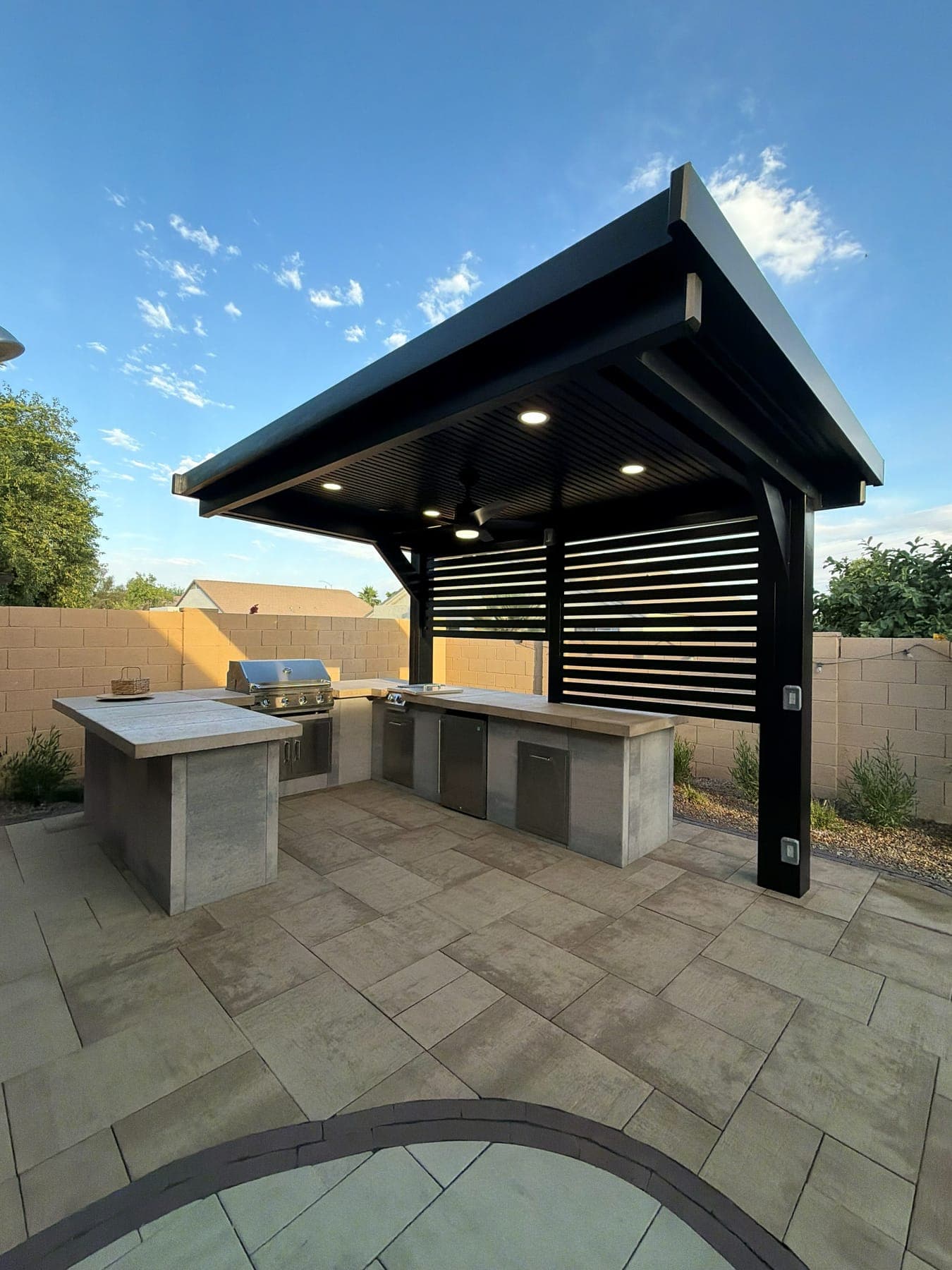 Covered outdoor living and kitchen under shade structure